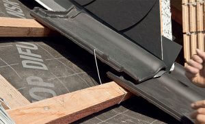Fot. 7. Klamrowanie dachówek, czyli przypinanie ich do łat, zapobiega podnoszeniu dachówek przez wiatr. Na połaci zaleca się klamrowanie co trzeciej dachówki po skosie, o ile lokalizacja budowy i specyfika dachu nie wymagają innych rozwiązań. 