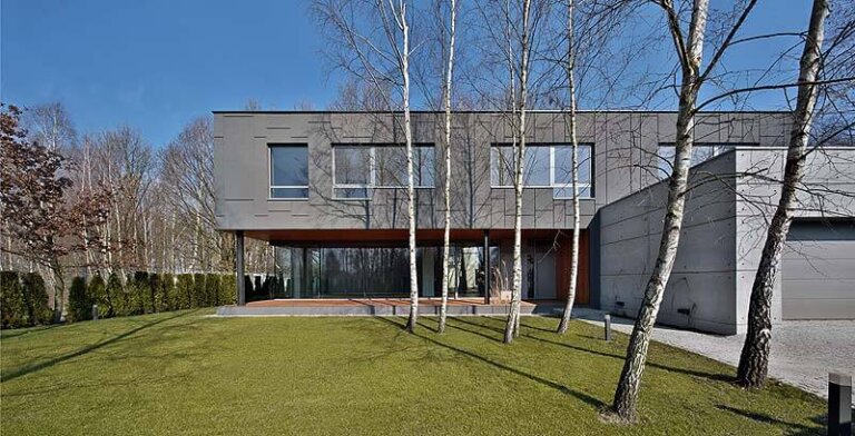 Dom jednorodzinny zlokalizowany we wsi Zielonki to jednolity kolorystycznie, podzielony pionowymi liniami, tynkowo-blaszany masyw z drewnianym miąższem.