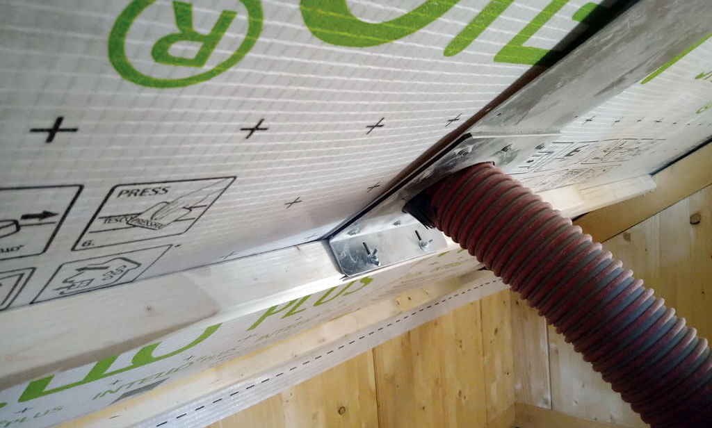 Montaż z pomocą dyszy w dachu spadzistym za folię Pro Clima Intello w dachu na obiekcie realizowanym przez firmę Partner Domy Drewniane (Szczecin).